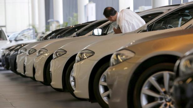 Ein Mann betrachtet die Autos in einem Autosalon.