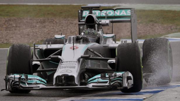 Ein Mercedes-Formel-1-Rennwagen fährt auf regennasser Strecke.