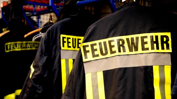 Feuerwehrjacken hängen an einer Kleiderstange.