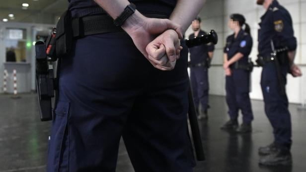 Polizisten in Uniform stehen in einem Gebäude.