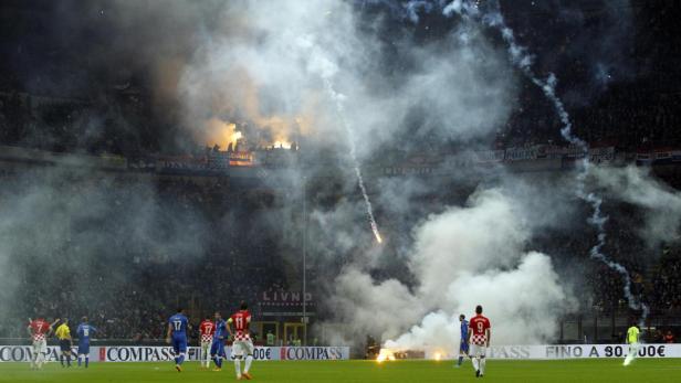 Während eines Fußballspiels zünden Fans Rauchbomben und Feuerwerkskörper.