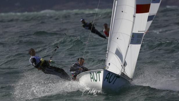 Ein österreichisches Segelboot mit zwei Personen fährt auf stürmischer See.