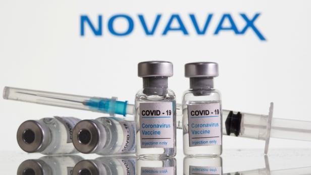 FILE PHOTO: FILE PHOTO: Vials labelled "COVID-19 Coronavirus Vaccine" and sryinge are seen in front of displayed Novavax logo in this illustration