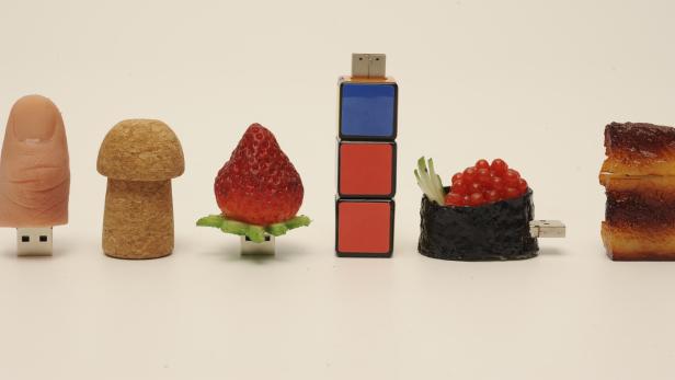 Kreative USB-Sticks in Form von Finger, Korken, Erdbeere, Zauberwürfel, Sushi und Speck.