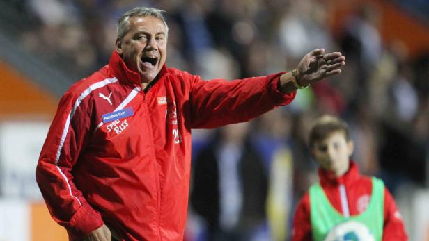 Ein Fußballtrainer gestikuliert während eines Spiels aufgeregt.