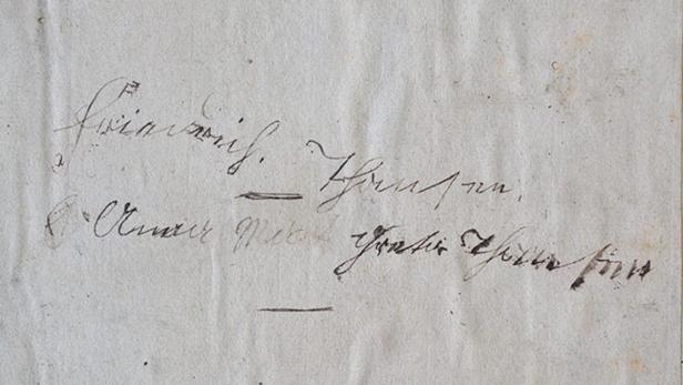Eine Seite mit schwer lesbarer, handschriftlicher Notiz in dunkler Tinte.