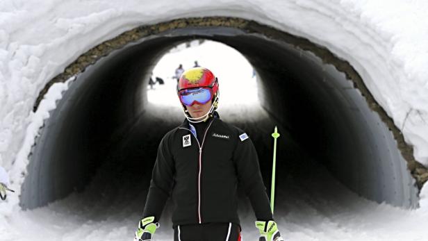 Ein Skifahrer steht vor einem Tunnel im Schnee.