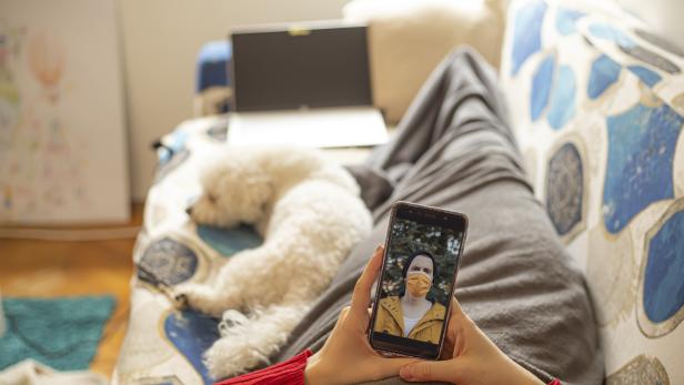 Junge Frau telefoniert per Videoanruf mit ihrem Freund über das Mobiltelefon.