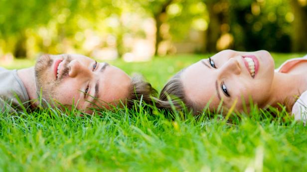 Happy couple in love laying on the floor outdoors