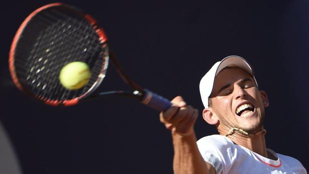 Ein Tennisspieler schlägt einen Ball mit seinem Schläger.
