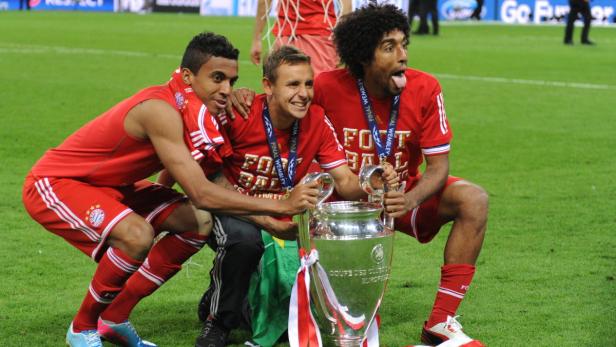 epa03717699 L-R) Munich&#039;s Luiz Gustavo, Rafinha and Dante celebrate with the trophy after winning the UEFA soccer Champions League final between Borussia Dortmund and Bayern Munich at Wembley stadium in London, Britain, 25 May 2013. Bayern won 2-1. EPA/ANDREAS GEBERT