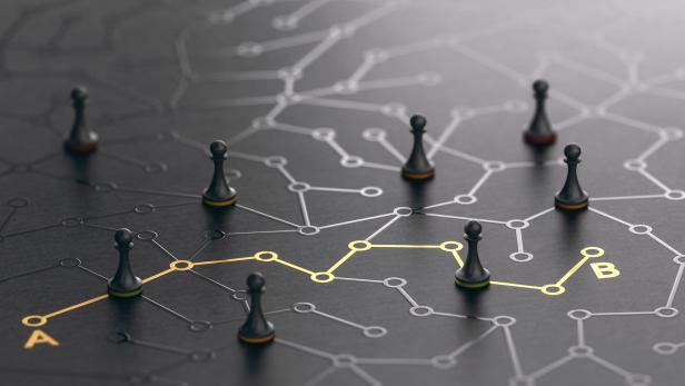 Schwarze Schachfiguren navigieren auf einem Netzwerk von Punkt A nach B.