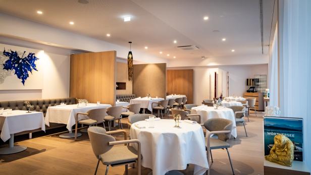 Ein elegantes Restaurant mit weiß gedeckten Tischen und hellen Holzdetails.