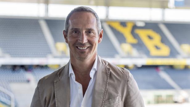 Ein lächelnder Mann im Stadion Wankdorf in Bern, im Hintergrund die gelben Buchstaben YB.