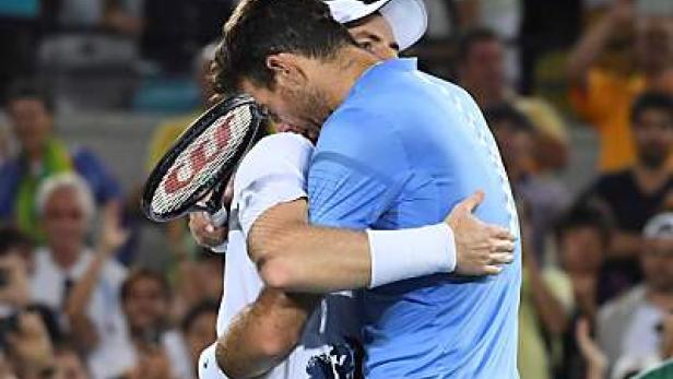 Zwei Tennisspieler umarmen sich nach einem Match.