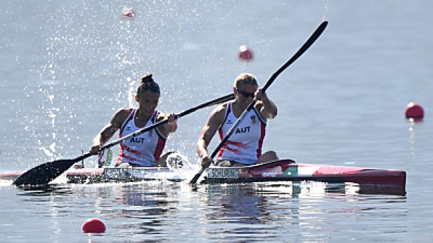 Zwei Kanutinnen des österreichischen Teams paddeln auf einem See.