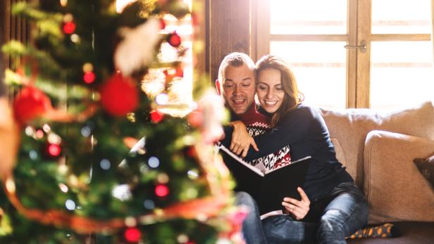 couple reading a book on christmas on the living room