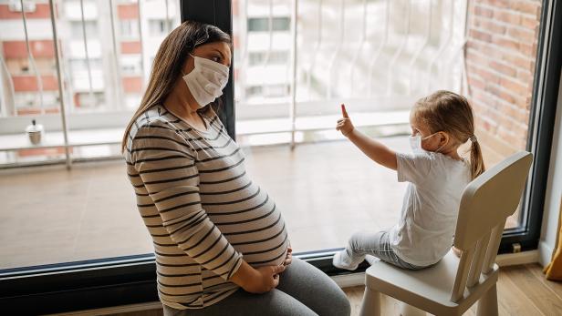 Pregnant women and daughter wearing n95 face mask and staying at home