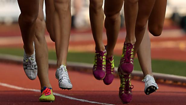 Mehrere Läufer sind auf einer roten Tartanbahn zu sehen.