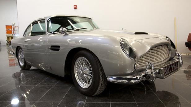 Ein silberner Aston Martin DB5 steht auf einem glänzenden Boden.