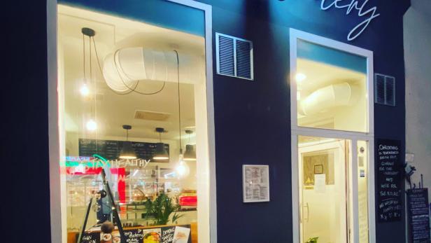 Die Fassade von „Zina's Eatery“ mit einem Schaufenster und einer einladenden Beleuchtung.