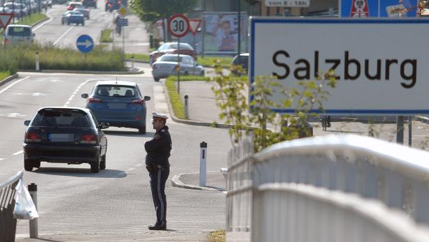 Ein österreichischer Polizist steht an einer Straße am Ortseingang von Salzburg.