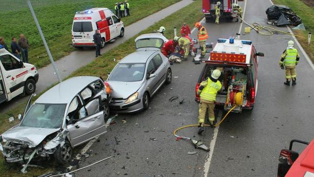 Nach einem Autounfall leisten Rettungskräfte und Feuerwehr Hilfe.
