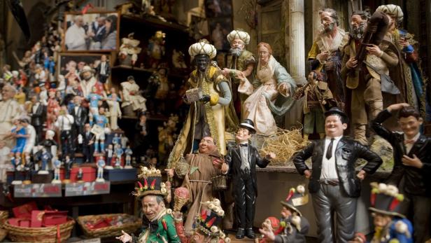 Eine Krippenszene mit zahlreichen Figuren, darunter Heilige Drei Könige und historische Persönlichkeiten.