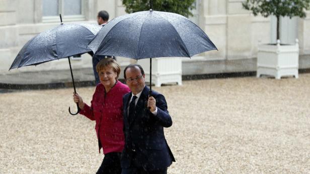 France&#039;s President Francois Hollande (R) and German Chancellor Angela Merkel (L) shelter from rain under umbrellas as they arrive at the Elysee Palace in Paris, May 30, 2013. REUTERS/Charles Platiau (FRANCE - Tags: POLITICS)