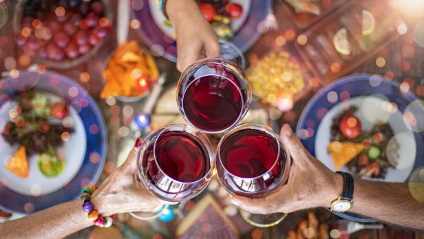 Familie stößt bei einem festlichen Abendessen mit Rotwein an.