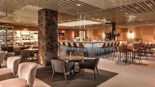 Ein elegant eingerichteter Barbereich mit Tischen und Stühlen für Gäste.