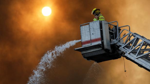 A firefighter works to extinguish a fire at a factory at the industrial park "FINSA II" in Santa Catarina