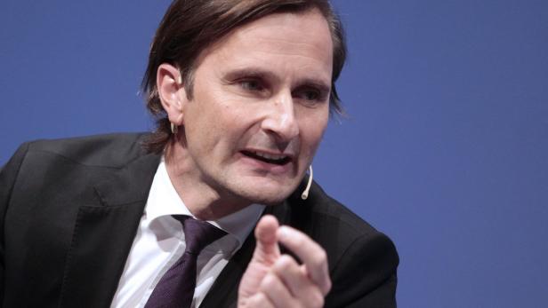 Christian Drosten bei einer Rede vor blauem Hintergrund.