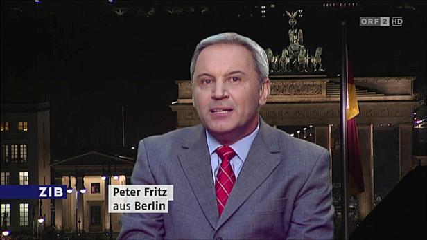 Peter Fritz vor dem Brandenburger Tor in Berlin bei Nacht.