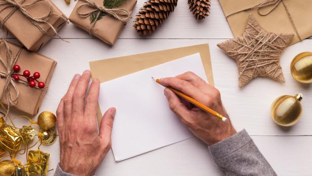 Erwachsener, der ein Brief ans Christkind schreibt.