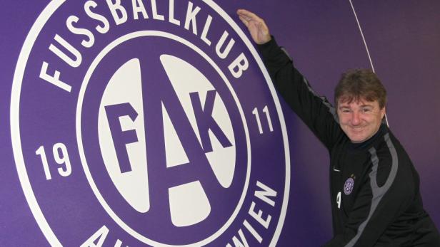 Ein Mann posiert vor dem Logo des Fussballklubs Austria Wien.