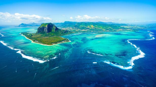 Der Berg Le Morne Brabant im Südwesten von Mauritius: Aus der Luft sieht man die Illusion eines Wasserfalls im Meer.