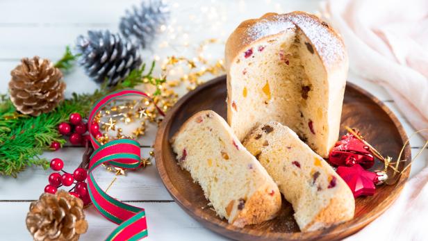 Panettone traditional Italian Christmas cake on wooden white table