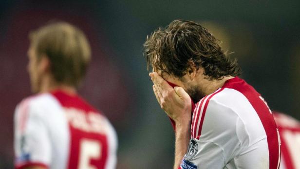 Ein Fußballspieler verdeckt sein Gesicht mit den Händen.