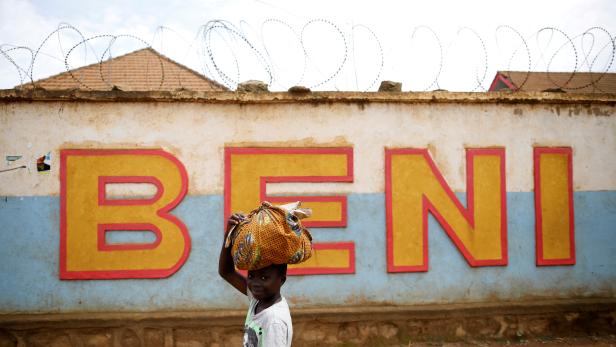 FILE PHOTO: A Congolese boy walks past a wall near the Alima Ebola treatment centre in Beni