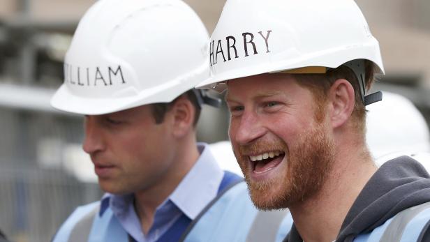 Prinz Harry und Prinz William tragen Schutzhelme und Sicherheitswesten.