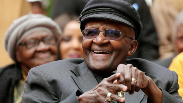 FILE PHOTO: Archbishop Desmond Tutu laughs as crowds gather to celebrate his birthday by unveiling an arch in his honour outside St George's Cathedral in Cape Town