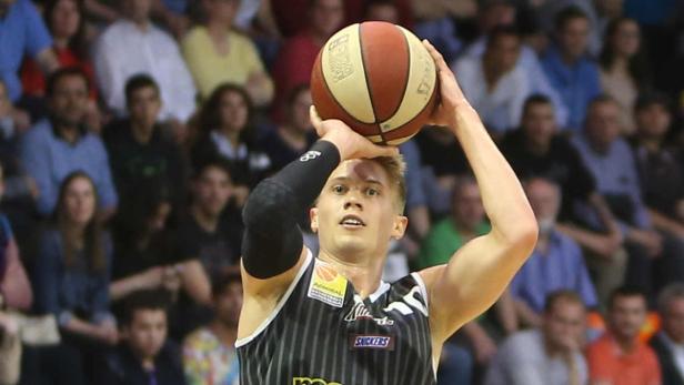 Ein Basketballspieler zielt auf den Korb.
