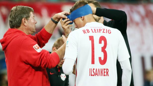 Einem Fußballspieler von RB Leipzig wird ein blauer Stirnverband angelegt.