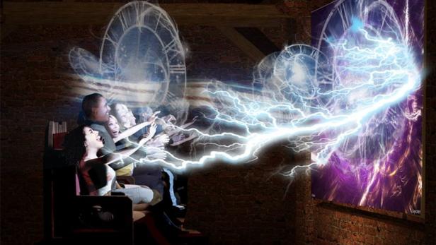 Eine Gruppe von Menschen sitzt in einem dunklen Raum und schaut auf eine Leinwand mit Blitzeffekten.