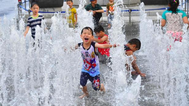 Abkühlen, bitte: Kinder in einem Springbrunnen in Seoul, Südkorea