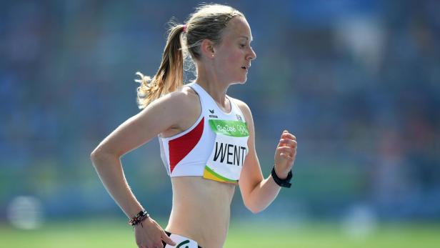 Eine blonde Frau läuft bei einem Sportwettkampf.
