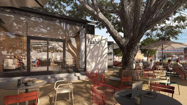 Ein Außenbereich des Restaurants „habs GU“ mit Gästen unter einem großen Baum.