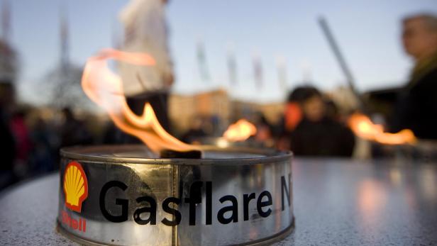 Eine Gasfackel mit dem Shell-Logo brennt auf einem Tisch.
