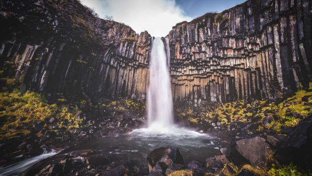 Der Svartifoss-Wasserfall im Skaftafell-Nationalpark in Island findet sich auf vielen Kalenderbildern, weil er sich weiß schäumend vor einem Hintergrund von schwarzen Basaltsäulen abhebt.